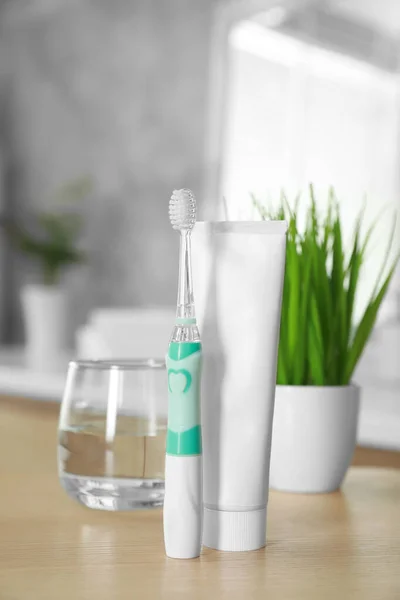 Electric Toothbrush Tube Paste Glass Water Wooden Table Bathroom — Stock Photo, Image