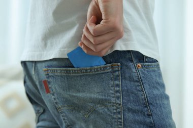 Bulanık arka planda prezervatif çeken adam, yakın plan.