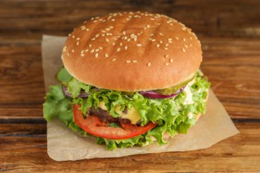 Köfteli leziz burger ve ahşap masada marul.