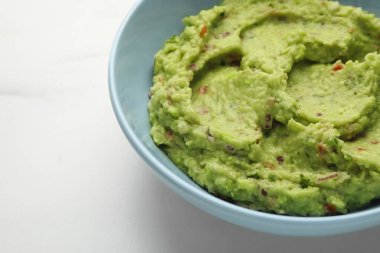 Lezzetli taze guacamole tabağı beyaz masada, yakın plan. Metin için boşluk