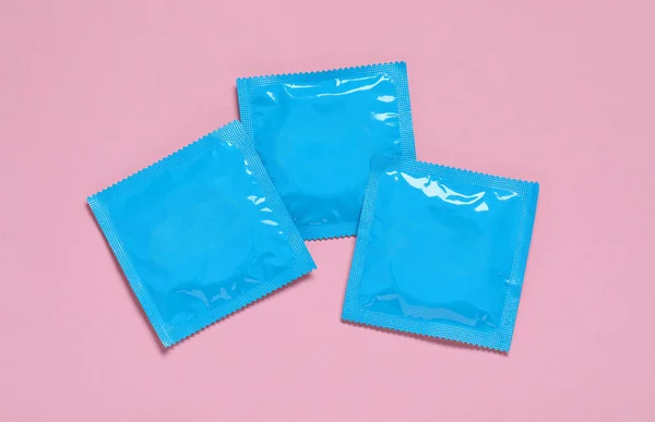 ピンクの背景 平らな層のコンドーム パッケージ 安全なセックス — ストック写真