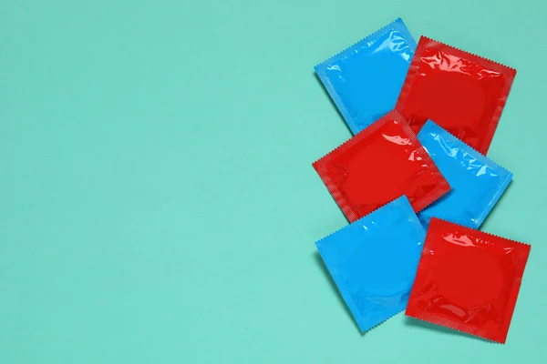 ターコイズの背景のコンドームパッケージ テキストのための平らな層とスペース 安全なセックス — ストック写真