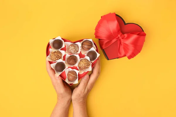 黄底巧克力糖果心形盒的女人 — 图库照片