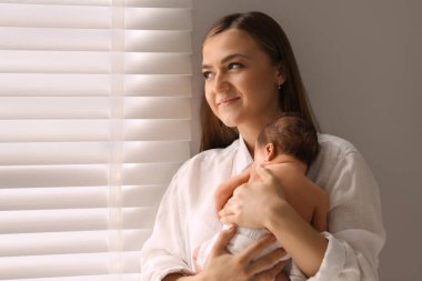 Anne yeni doğmuş bebeğini kucağında tutuyor.
