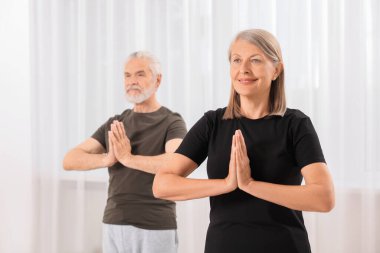 Üst düzey çift evde yoga yapıyor, seçici odaklanma.