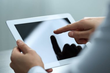 Açık gri arkaplanda tablet kullanan adam, yakın plan