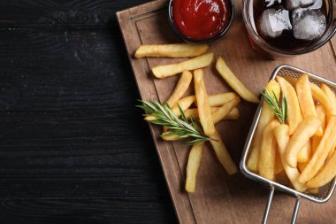 Lezzetli patates kızartması, ketçap ve soda. Koyu ahşap masa, üst manzara. Metin için boşluk