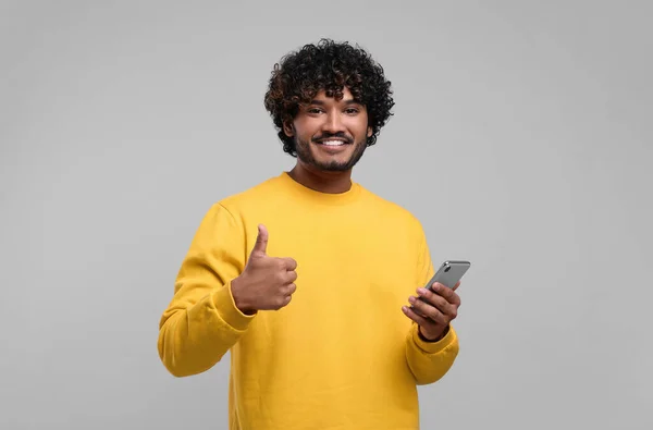 Hombre Sonriente Guapo Usando Teléfono Inteligente Mostrando Los Pulgares Hacia —  Fotos de Stock