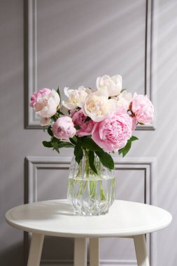 Beyaz masadaki cam vazodaki güzel şakayıklar