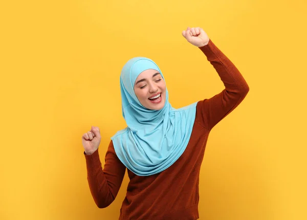 オレンジ色の背景で踊るヒジャブのムスリム女性 — ストック写真