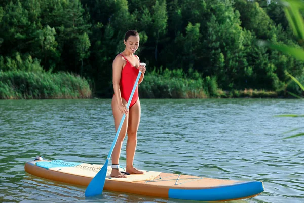 川のSupボードに搭乗する女性パドル — ストック写真