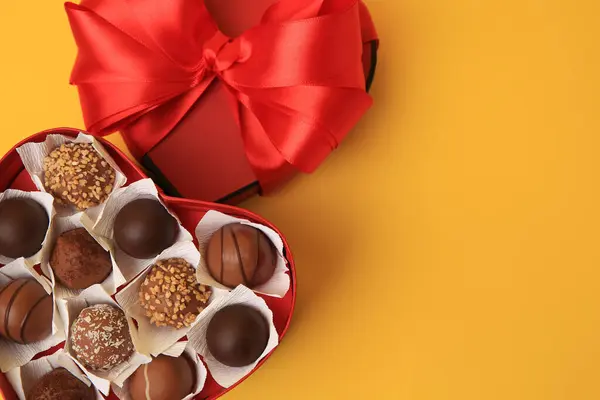 心形盒 黄色背景的巧克力糖果味道鲜美 案文的篇幅 — 图库照片
