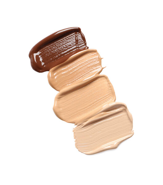 Samples of skin foundation on white background, top view