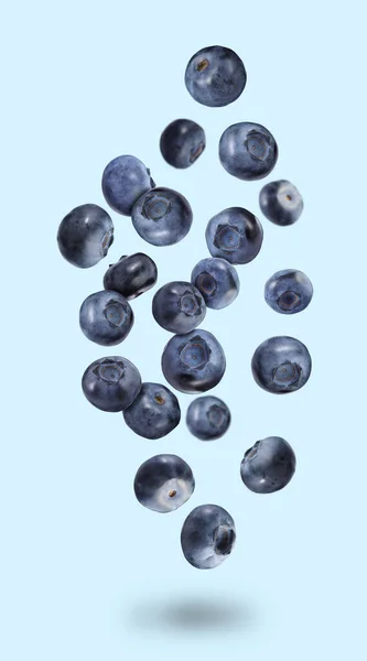 Many Ripe Blueberries Falling Light Blue Background — Stock Photo, Image
