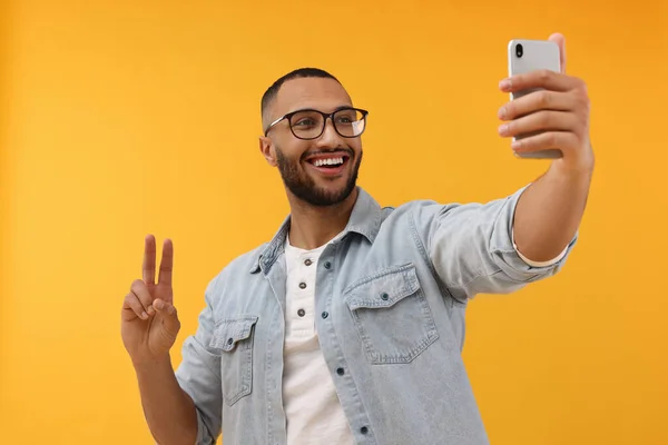 Joven Sonriente Tomando Selfie Con Smartphone Mostrando Signo Paz Sobre —  Fotos de Stock