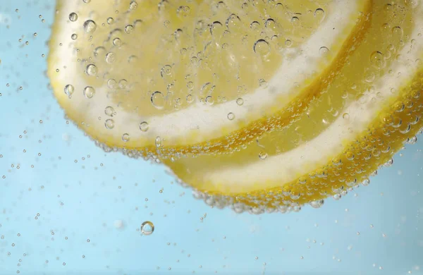 Saftige Zitronenscheiben Sodawasser Vor Hellblauem Hintergrund Nahaufnahme — Stockfoto
