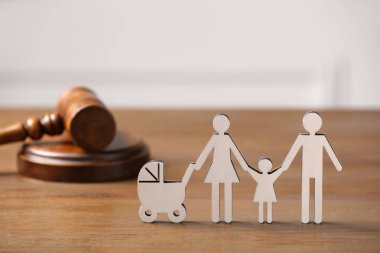 Aile hukuku. Çocuklu ebeveyn figürü ve tahta masa üzerinde tokmak, metin için alan