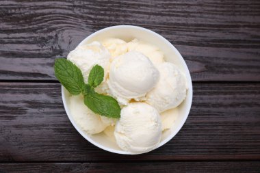 Lezzetli vanilyalı dondurma ve nane şekeri ahşap masada, üst tarafta.