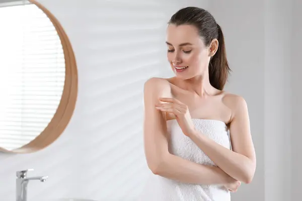 バスルーム テキストのためのスペースで腕にボディオイルを適用する幸せな女性 — ストック写真