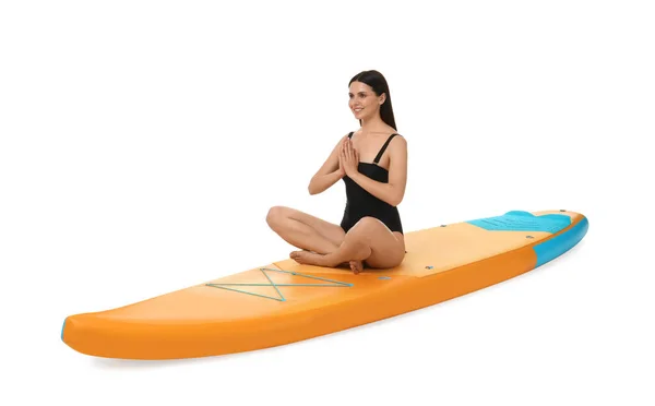 在白色背景的橙色Sup板上练习瑜伽的快乐女人 — 图库照片