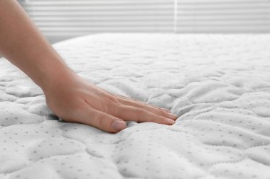 Yumuşak açık yeşil şilteye dokunan kadın, kapalı alanda, yakın plan.