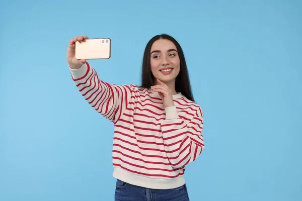 Sorrindo Jovem Mulher Tomando Selfie Com Smartphone Fundo Azul Claro — Fotografia de Stock