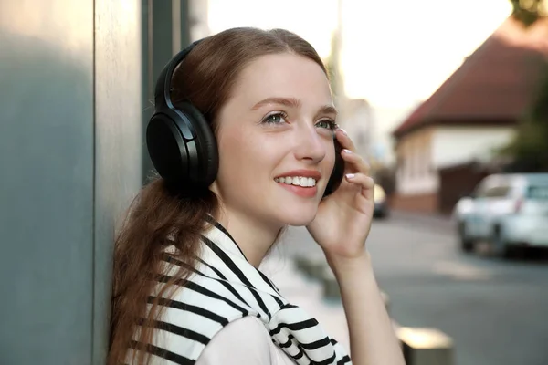 Mujer Sonriente Con Auriculares Escuchando Música Cerca Del Edificio Aire —  Fotos de Stock