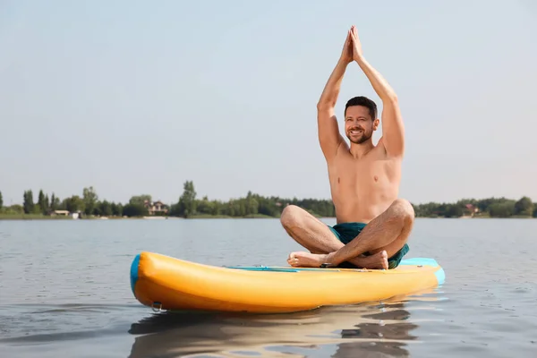 男子在河上的Sup上练习瑜伽 — 图库照片