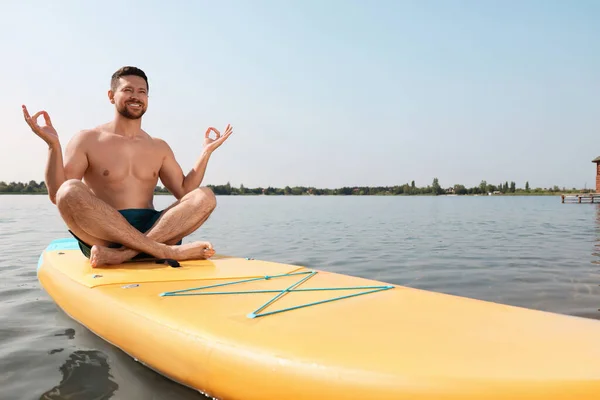 男子在河上的Sup上练习瑜伽 — 图库照片