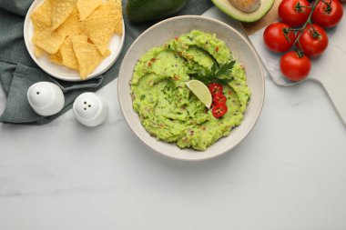 Nachos cipsli nefis guacamole ve beyaz mermer masada malzemeler, düz yatak. Metin için boşluk