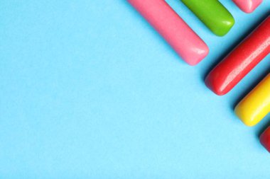 Açık mavi arkaplanda pek çok lezzetli baloncuk sakızı var. Metin için boşluk