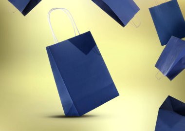 Satılık. Mavi alışveriş torbaları altın renkte arka planda