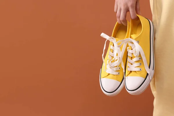 Mujer Con Zapatillas Clásicas Amarillas Vieja Escuela Sobre Fondo Marrón —  Fotos de Stock
