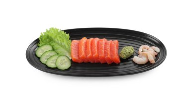 Lezzetli sashimi seti (çiğ somon ve karides dilimleri) salatalık, marul ve wasabi ile servis edilir.