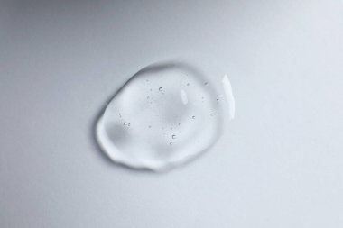 Beyaz arka planda kozmetik yağı damlası, üst görünüm