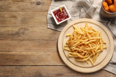 Lezzetli ketçap, patates kızartması ve tavuklu nugget, ahşap masa, düz yatak. Metin için boşluk