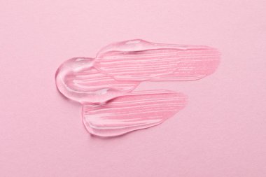 Pembe arka planda kozmetik jel örnekleri, üst görünüm