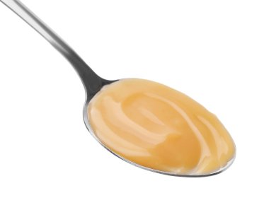 Lezzetli karamelli kaşık beyaz üzerine izole edilmiş.