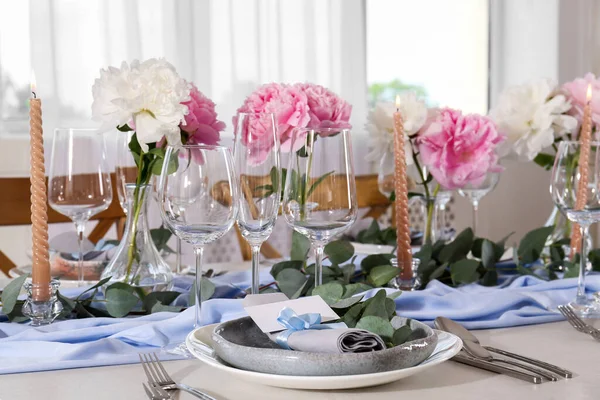美しいテーブルセッティング グリーティングカード ナプキンと眼鏡 部屋のテーブルの上にろうそくやカトラリーの近くの枝を持つプレート — ストック写真
