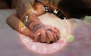 Cinsel uyumluluk. Zodiac tekerleği ve tutkulu bir çift yatakta sevişiyor, elleri kapalı.