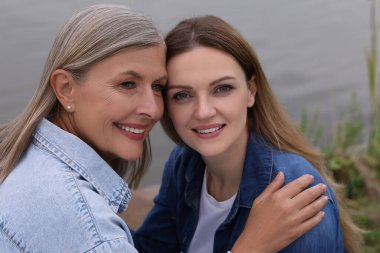 Mutlu olgun anne ve kızı göletin kenarında