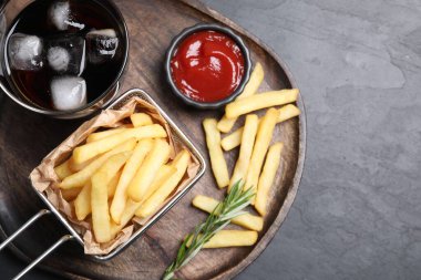 Lezzetli patates kızartması, ketçap ve soda siyah masada.