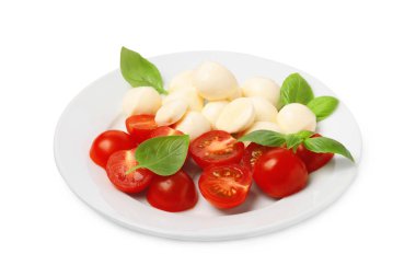 Bir tabak lezzetli Caprese salatası, domatesli, mozzarella ve fesleğenli beyaz.