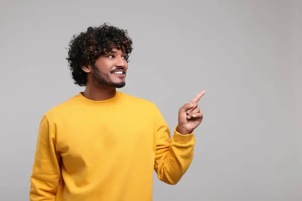 stock image Handsome smiling man on light grey background, space for text