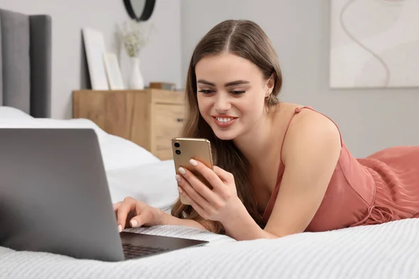 Щаслива Жінка Смартфоном Ноутбуком Ліжку Спальні — стокове фото