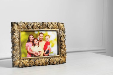 Beyaz ahşap masa üzerinde çerçeveli aile fotoğrafı, metin için boşluk