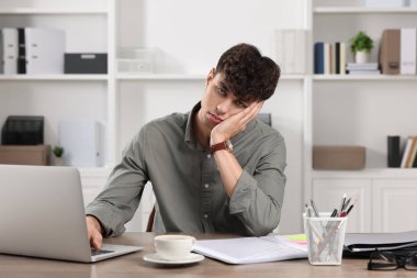 Ofiste çalışan yorgun genç bir adam. Son teslim tarihi kavramı