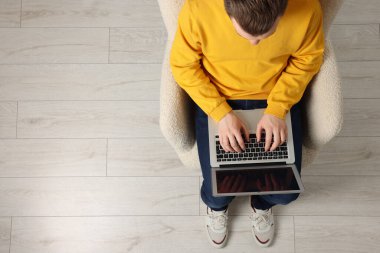 Koltukta dizüstü bilgisayarla çalışan bir adam. Metin için boşluk