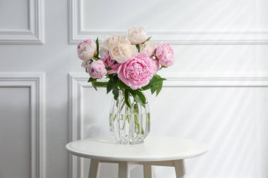 Beyaz masadaki cam vazodaki güzel şakayıklar