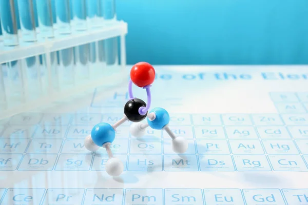 Modèle Moléculaire Éprouvettes Sur Table Périodique Sur Fond Bleu Clair — Photo